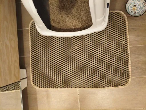Tapis de litière kaki posé devant une maison de toilette pour chat