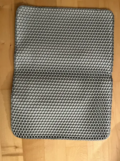 Photo d'un acheteur montrant le tapis de litière Minopatte en situation