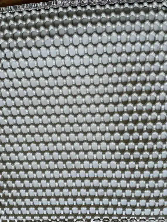 Gros plan sur les alvéoles de la couche supérieure du tapis